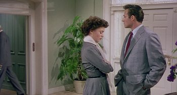 Movie still from “This Island Earth” (1955), directed by Joseph M. Newman – A man and a woman standing next to each other in front of a potted plant; Medium shot, Over the shoulder angle