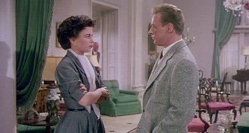 Movie still from “This Island Earth” (1955), directed by Joseph M. Newman – An older woman talking to a man in a suit; Medium shot, Over the shoulder angle