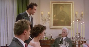 Movie still from “This Island Earth” (1955), directed by Joseph M. Newman – A group of people sitting at a table with wine glasses; Medium shot, Over the shoulder angle