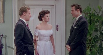 Movie still from “This Island Earth” (1955), directed by Joseph M. Newman – Two men and a woman standing in front of a door; Medium shot, Over the shoulder angle