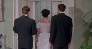 Movie still from “This Island Earth” (1955), directed by Joseph M. Newman – A group of people standing next to each other in front of a door; Medium shot, Low angle