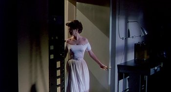 Movie still from “This Island Earth” (1955), directed by Joseph M. Newman – A woman in a white dress holding a remote control; Wide shot, Low angle