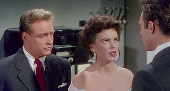 Movie still from “This Island Earth” (1955), directed by Joseph M. Newman – A man and a woman standing next to each other in front of an oven; Close Up shot, Over the shoulder angle