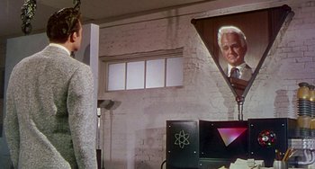 Movie still from “This Island Earth” (1955), directed by Joseph M. Newman – A man standing in front of a painting of an older man; Medium shot, Over the shoulder angle