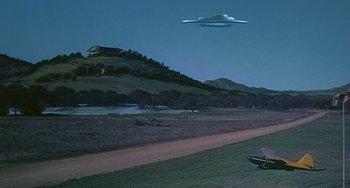 Movie still from “This Island Earth” (1955), directed by Joseph M. Newman – An image of an airplane that is flying in the sky; Extreme Wide shot, Low angle