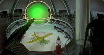 Movie still from “This Island Earth” (1955), directed by Joseph M. Newman – An airplane is sitting on a conveyor belt in a factory; Wide shot, Low angle