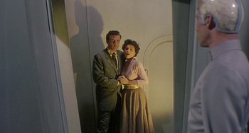 Movie still from “This Island Earth” (1955), directed by Joseph M. Newman – A man and a woman standing next to each other in front of a wall; Medium shot, Low angle
