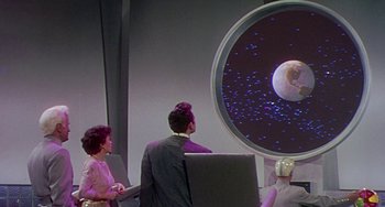 Movie still from “This Island Earth” (1955), directed by Joseph M. Newman – A man and a woman are looking at a screen; Extreme Wide shot, Low angle