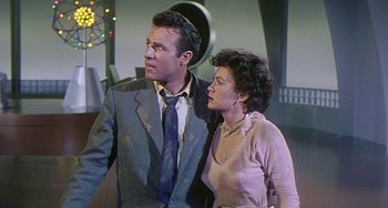 Movie still from “This Island Earth” (1955), directed by Joseph M. Newman – A man and a woman standing next to each other; Medium shot, Low angle