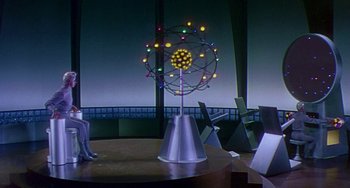 Movie still from “This Island Earth” (1955), directed by Joseph M. Newman – A table that has a clock on top of it; Wide shot, High angle