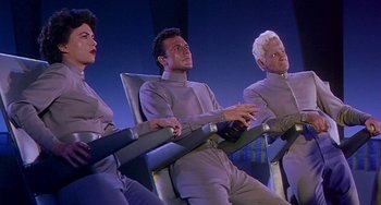 Movie still from “This Island Earth” (1955), directed by Joseph M. Newman – A group of people sitting in a row of chairs; Medium shot, Low angle