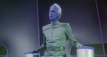 Movie still from “This Island Earth” (1955), directed by Joseph M. Newman – A man in a green suit holding two buckets; Medium shot, Low angle