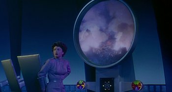Movie still from “This Island Earth” (1955), directed by Joseph M. Newman – A woman standing in front of a large screen; Medium shot, Low angle