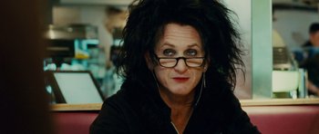 Movie still from “This Must Be the Place” (2011), directed by Paolo Sorrentino – A person wearing glasses and a black jacket; Close Up shot, Over the shoulder angle