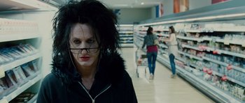 Movie still from “This Must Be the Place” (2011), directed by Paolo Sorrentino – A woman in a black jacket and some people in a store; Close Up shot, Over the shoulder angle