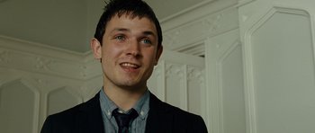 Movie still from “This Must Be the Place” (2011), directed by Paolo Sorrentino – A man in a suit and tie smiling for the camera; Close Up shot, Low angle