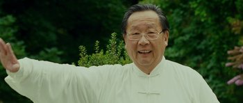 Movie still from “This Must Be the Place” (2011), directed by Paolo Sorrentino – An older man wearing glasses and a white shirt is smiling; Close Up shot, Low angle