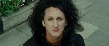 Movie still from “This Must Be the Place” (2011), directed by Paolo Sorrentino – A person with long black hair; Close Up shot, High angle