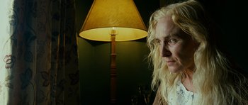 Movie still from “This Must Be the Place” (2011), directed by Paolo Sorrentino – A woman standing in front of a lamp in a room; Close Up shot, Low angle