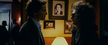 Movie still from “This Must Be the Place” (2011), directed by Paolo Sorrentino – Two men in a room talking to each other in front of a lamp; Close Up shot, Over the shoulder angle