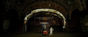 Movie still from “This Must Be the Place” (2011), directed by Paolo Sorrentino – A man standing next to a cart in an abandoned building; Extreme Wide shot, Low angle