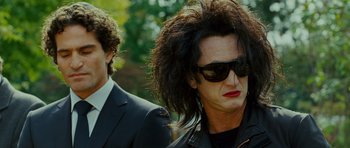 Movie still from “This Must Be the Place” (2011), directed by Paolo Sorrentino – A man and a woman wearing sunglasses and a black jacket; Close Up shot, Over the shoulder angle