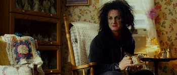 Movie still from “This Must Be the Place” (2011), directed by Paolo Sorrentino – A person sitting in a chair with a black shirt on; Medium shot, Over the shoulder angle
