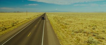 Movie still from “This Must Be the Place” (2011), directed by Paolo Sorrentino – A car driving down the middle of a road; Extreme Wide shot, High angle
