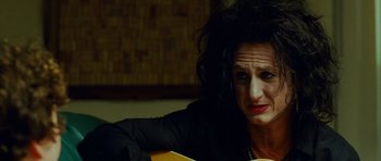 Movie still from “This Must Be the Place” (2011), directed by Paolo Sorrentino – A woman sitting in front of an orange guitar; Close Up shot, Over the shoulder angle
