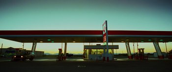 Movie still from “This Must Be the Place” (2011), directed by Paolo Sorrentino – An empty gas station at dusk with a truck parked in front of it; Extreme Wide shot, Low angle