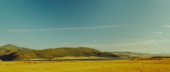 Movie still from “This Must Be the Place” (2011), directed by Paolo Sorrentino – A field with a lake and a mountain in the background; Extreme Wide shot, High angle