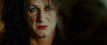 Movie still from “This Must Be the Place” (2011), directed by Paolo Sorrentino – A person's face in a dark room; Close Up shot, Over the shoulder angle