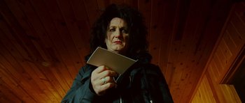 Movie still from “This Must Be the Place” (2011), directed by Paolo Sorrentino – A woman in a black jacket holding a book; Close Up shot, Low angle