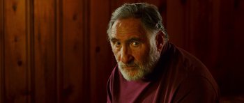 Movie still from “This Must Be the Place” (2011), directed by Paolo Sorrentino – An older man with a beard and a red shirt; Close Up shot, Over the shoulder angle