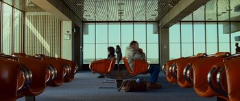 Movie still from “This Must Be the Place” (2011), directed by Paolo Sorrentino – Two people are sitting in an airport terminal; Wide shot, Low angle