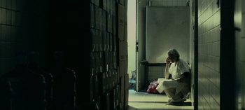 Movie still from “Three Monkeys” (2008), directed by Nuri Bilge Ceylan – A man sitting on the floor of a room; Wide shot, Low angle