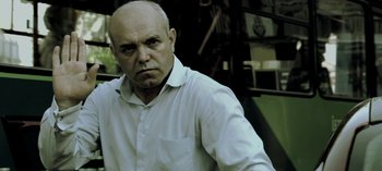 Movie still from “Three Monkeys” (2008), directed by Nuri Bilge Ceylan – A man with a bald head wearing a white shirt; Close Up shot, Low angle