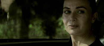 Movie still from “Three Monkeys” (2008), directed by Nuri Bilge Ceylan – A person in a car with trees in the background; Close Up shot, Over the shoulder angle