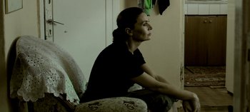 Movie still from “Three Monkeys” (2008), directed by Nuri Bilge Ceylan – A woman sitting in a chair looking out a window; Close Up shot, High angle
