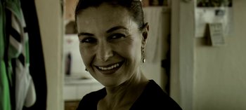 Movie still from “Three Monkeys” (2008), directed by Nuri Bilge Ceylan – A person smiling for the camera; Close Up shot, Low angle