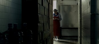 Movie still from “Three Monkeys” (2008), directed by Nuri Bilge Ceylan – An older woman standing next to a stack of boxes in a kitchen; Medium shot, Low angle