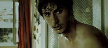 Movie still from “Three Monkeys” (2008), directed by Nuri Bilge Ceylan – A person in a bathroom near a shower; Close Up shot, Low angle