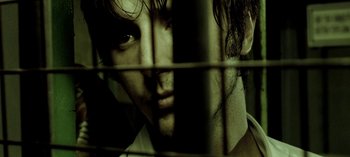 Movie still from “Three Monkeys” (2008), directed by Nuri Bilge Ceylan – A person behind a fence; Extreme Close Up shot, Low angle