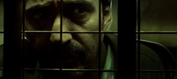 Movie still from “Three Monkeys” (2008), directed by Nuri Bilge Ceylan – A person looking through a cage; Extreme Close Up shot, Low angle