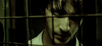 Movie still from “Three Monkeys” (2008), directed by Nuri Bilge Ceylan – A person behind a fence; Extreme Close Up shot, Low angle