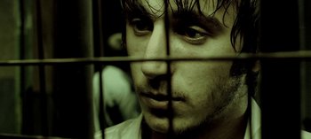 Movie still from “Three Monkeys” (2008), directed by Nuri Bilge Ceylan – A person behind a fence; Close Up shot, Low angle