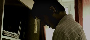 Movie still from “Three Monkeys” (2008), directed by Nuri Bilge Ceylan – A person with his head down; Close Up shot, Low angle