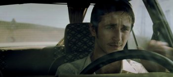 Movie still from “Three Monkeys” (2008), directed by Nuri Bilge Ceylan – A man sitting in the driver's seat of a car; Close Up shot, Over the shoulder angle