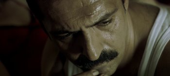 Movie still from “Three Monkeys” (2008), directed by Nuri Bilge Ceylan – A man's face with his hand under his chin; Extreme Close Up shot, High angle