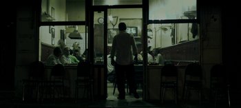Movie still from “Three Monkeys” (2008), directed by Nuri Bilge Ceylan – A group of people sitting at a table in a restaurant; Wide shot, Low angle